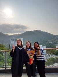 Karlygach (first from left) in her academic gown with two other College students on campus